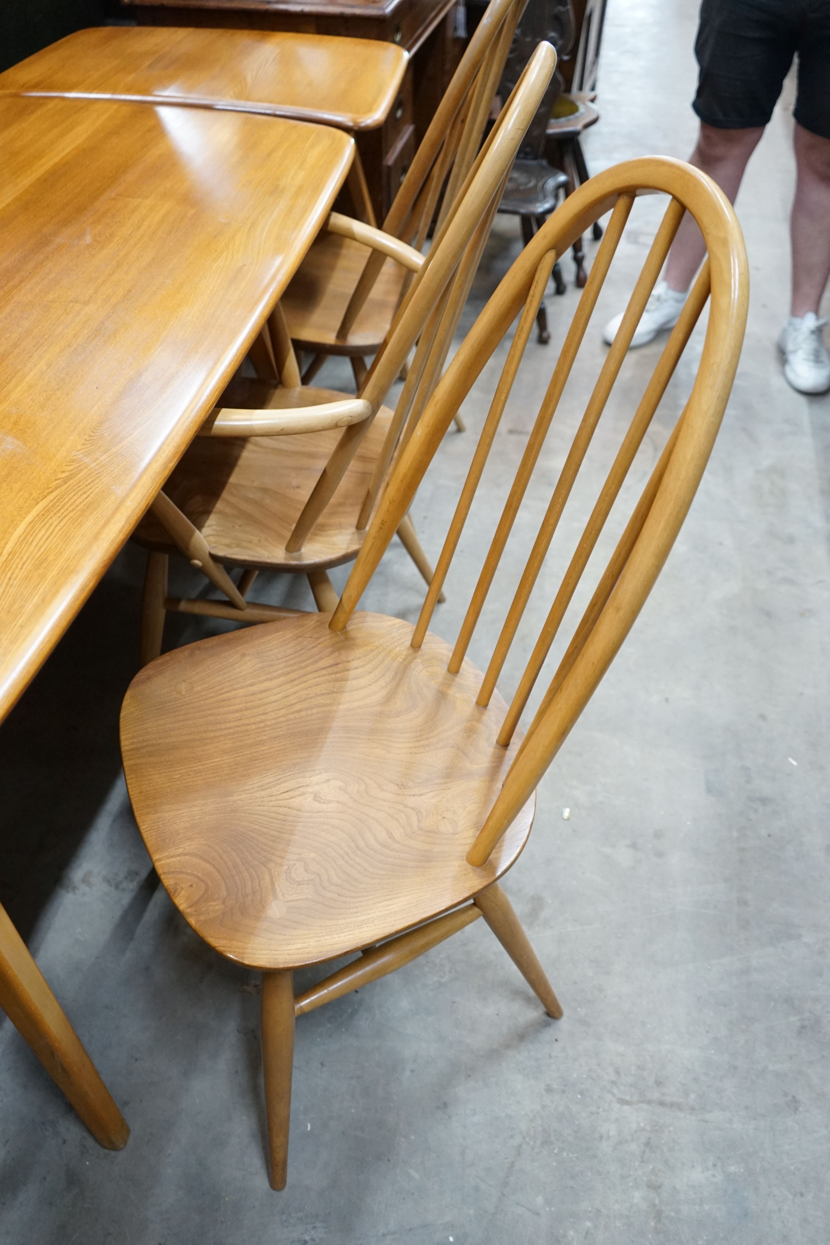 An Ercol rectangular light elm dining table with extension section, length 150cm, depth 76cm, height 72cm and three Ercol elm and beech comb back chairs, one with arms